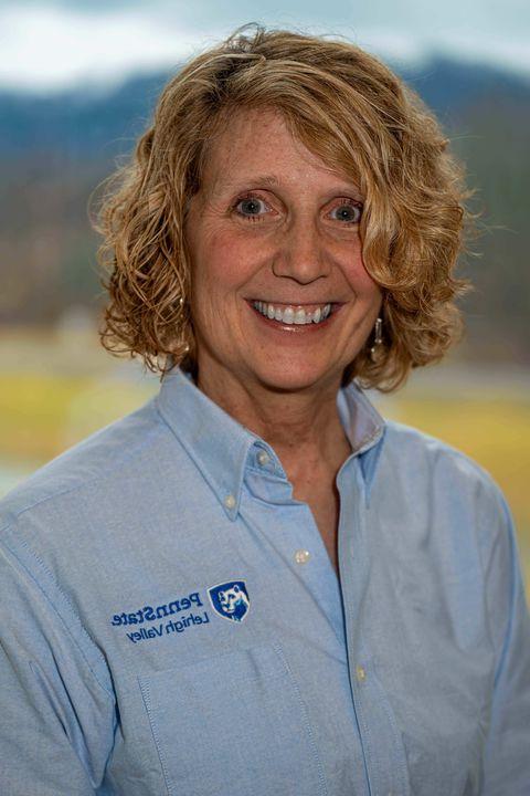 Woman with chin-length wavy blonde hair smiling.